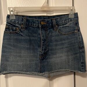 Free people denim skirt with frayed  hem. Never worn no tags size 0.